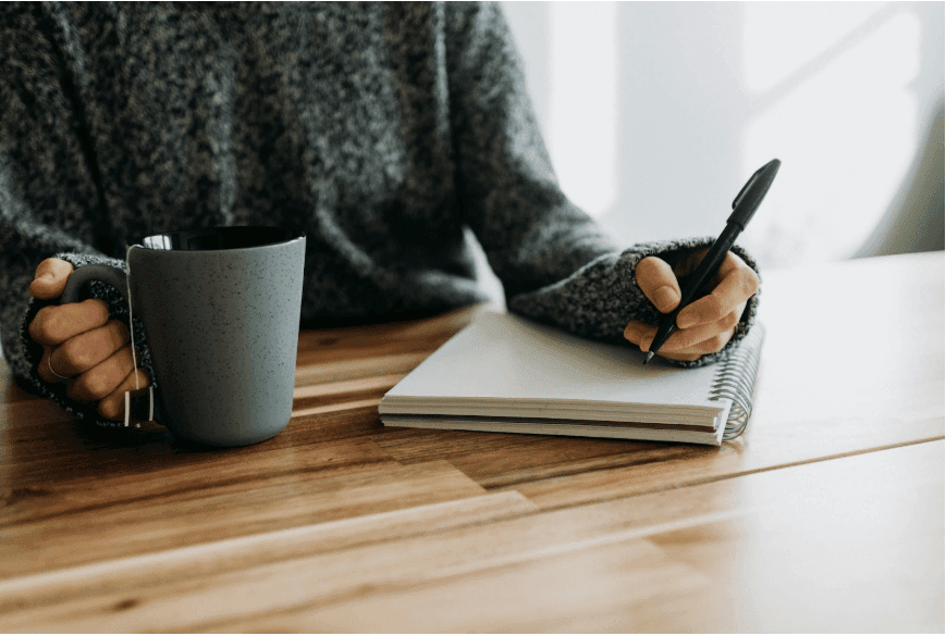 A female business owner tries writing down CTAs for her website in a notebook