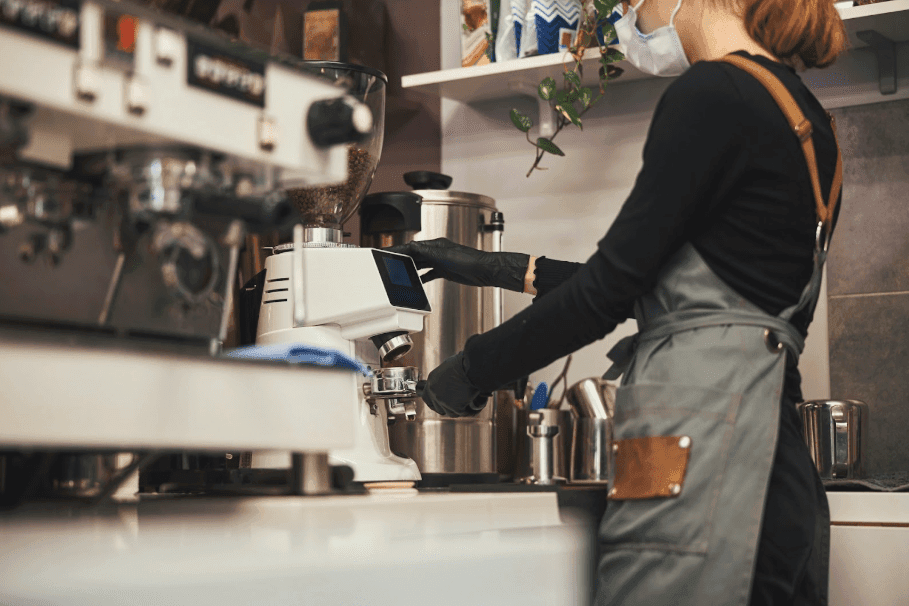 A woman working in a cafe making coffee, a local business for Edmonton