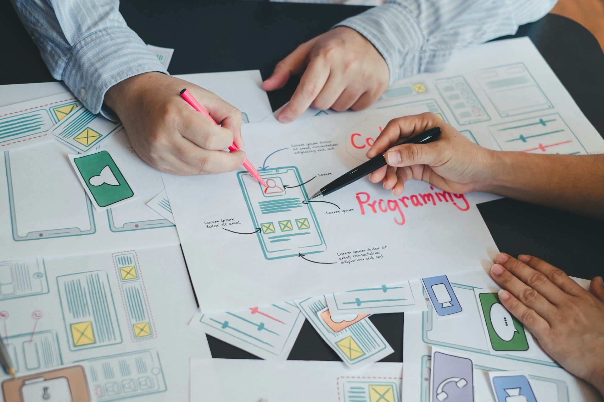 Two people working over mobile app plans to ensure it’s completely user-friendly