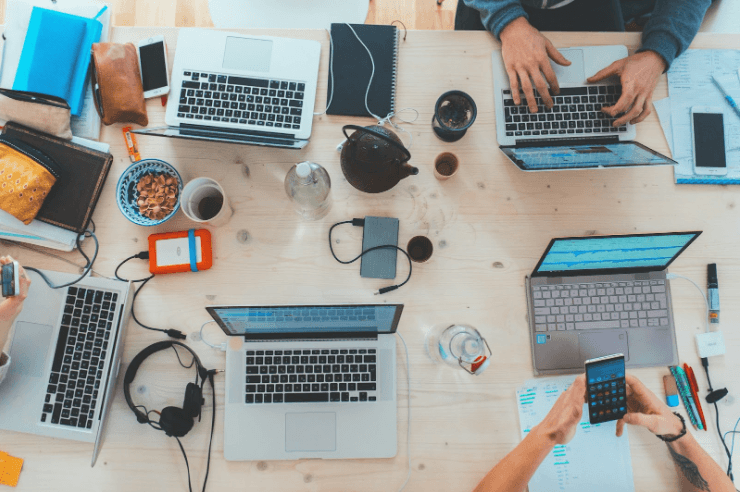 A top-down view of a desk inside a web design company, employees working for clients