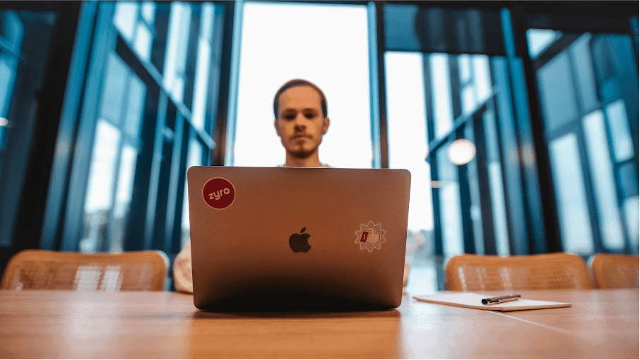  A man sitting in a cafe working on building his website on his laptop
