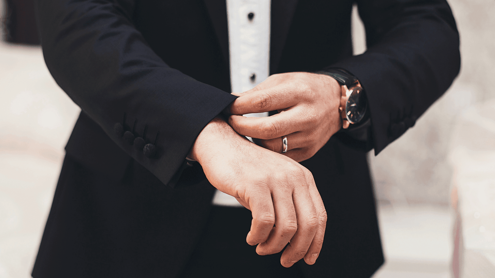 A mid-shot of a man wearing a suit jacket, cropped at the waist, exuding a professional and confident presence.