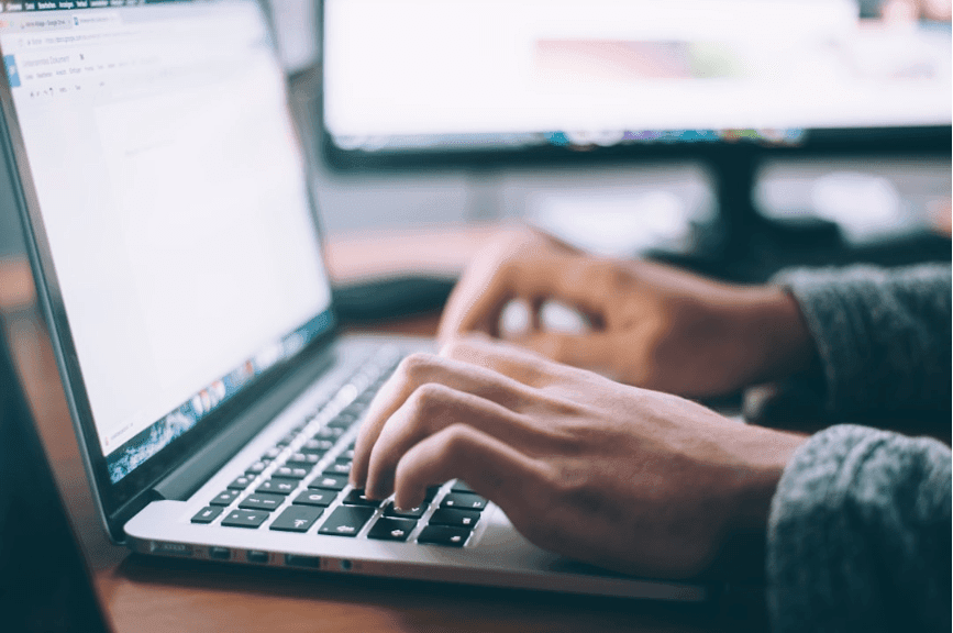 Person typing on a laptop keyboard.