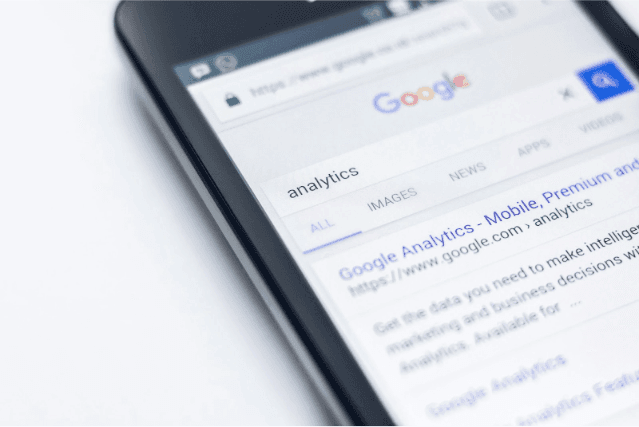A close-up of a smartphone with Google Analytics open on the search screen