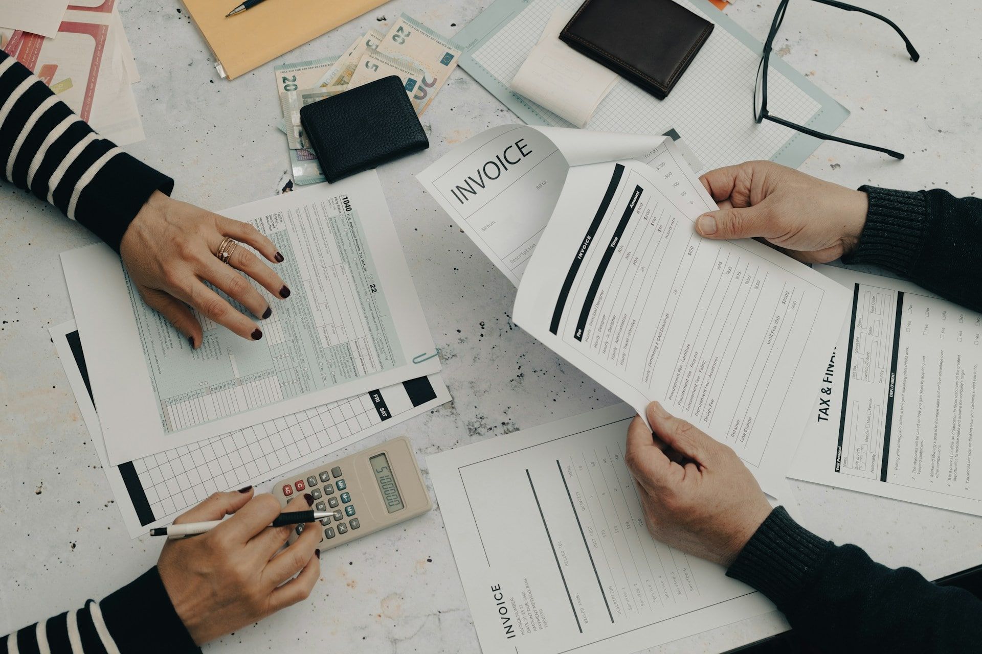 A cluttered looking desk filled with financial documents and business budget plans