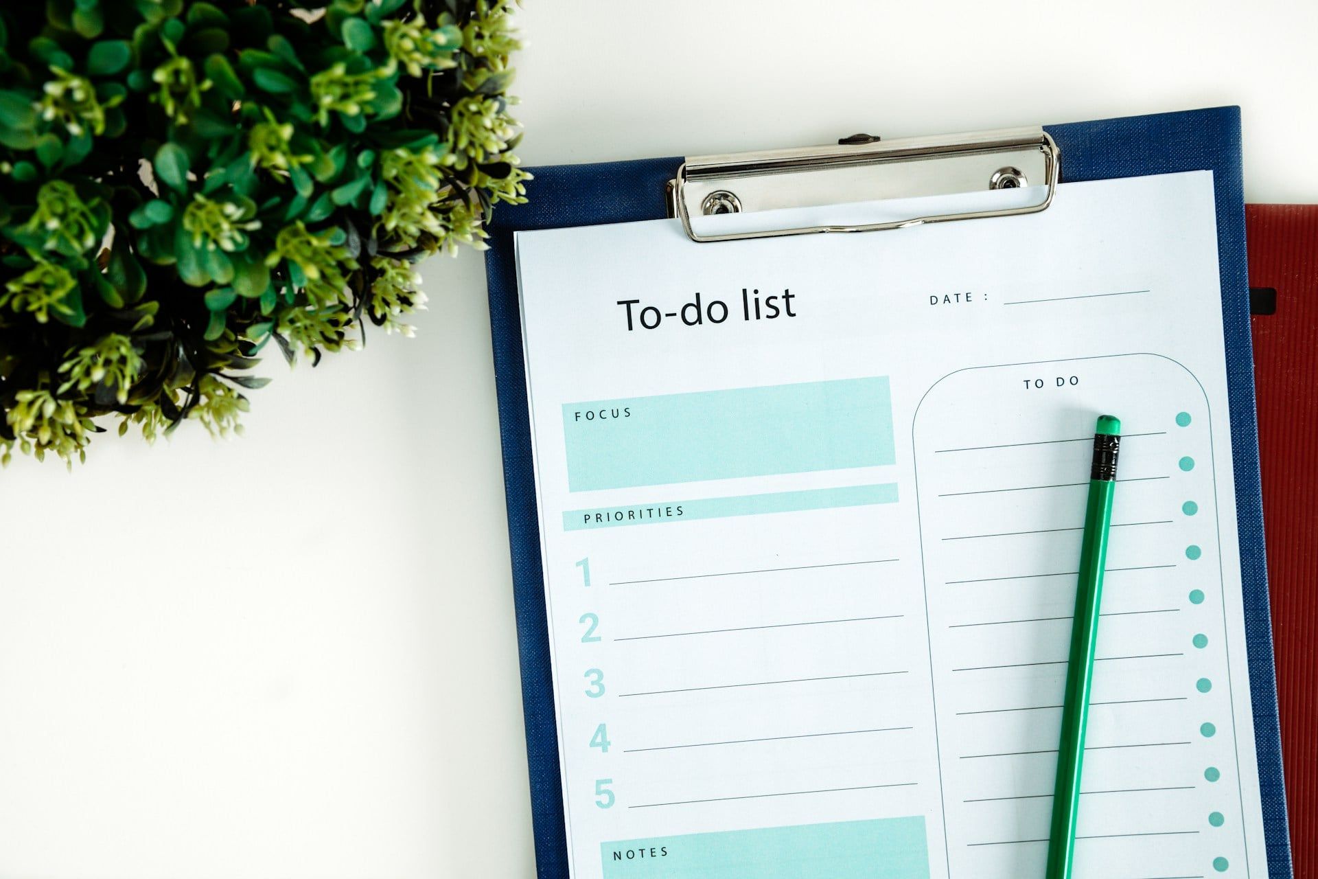 A clipboard with a green pencil on it and a to-do list template attached