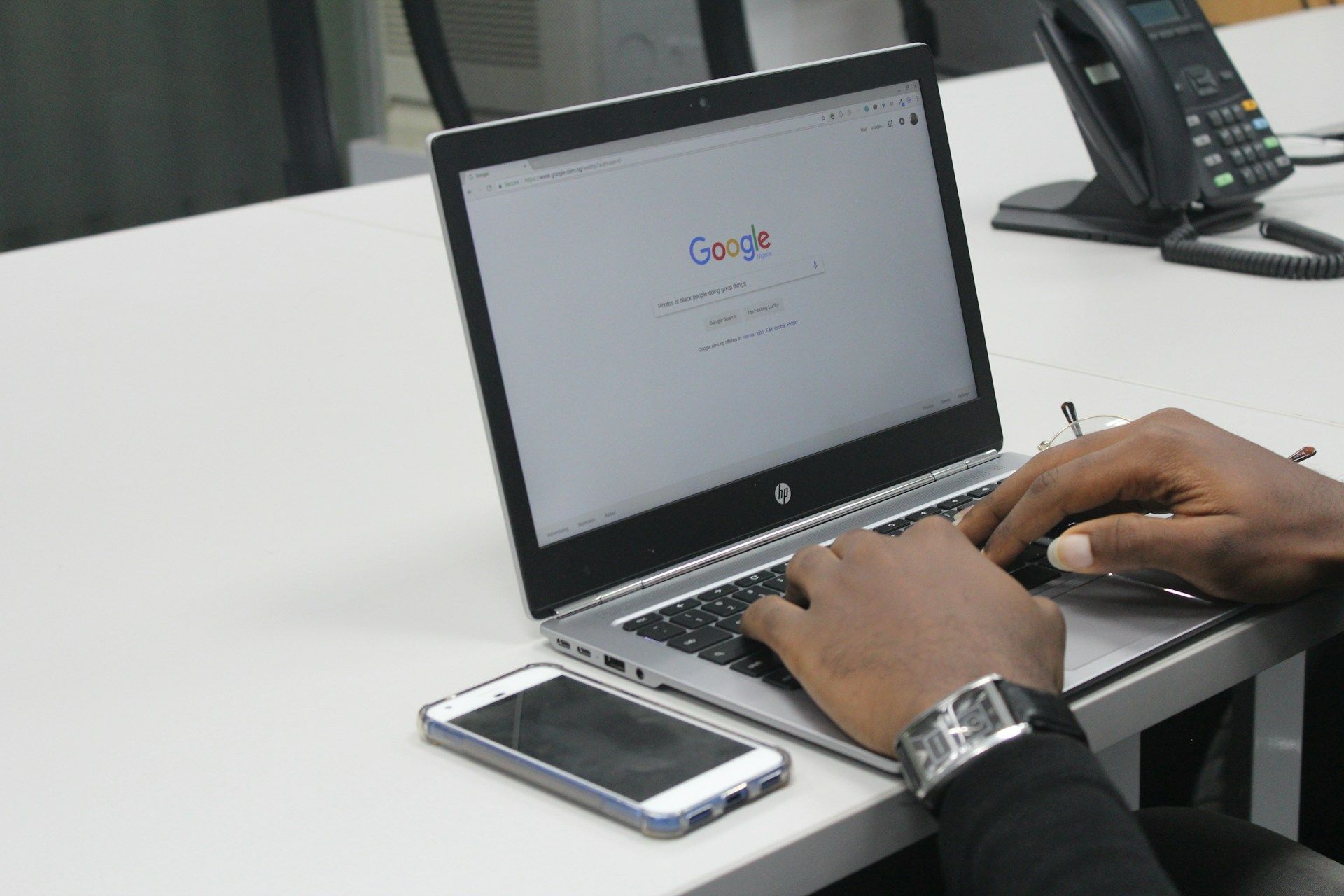 A marketer searching someone into Google’s homepage from their laptop