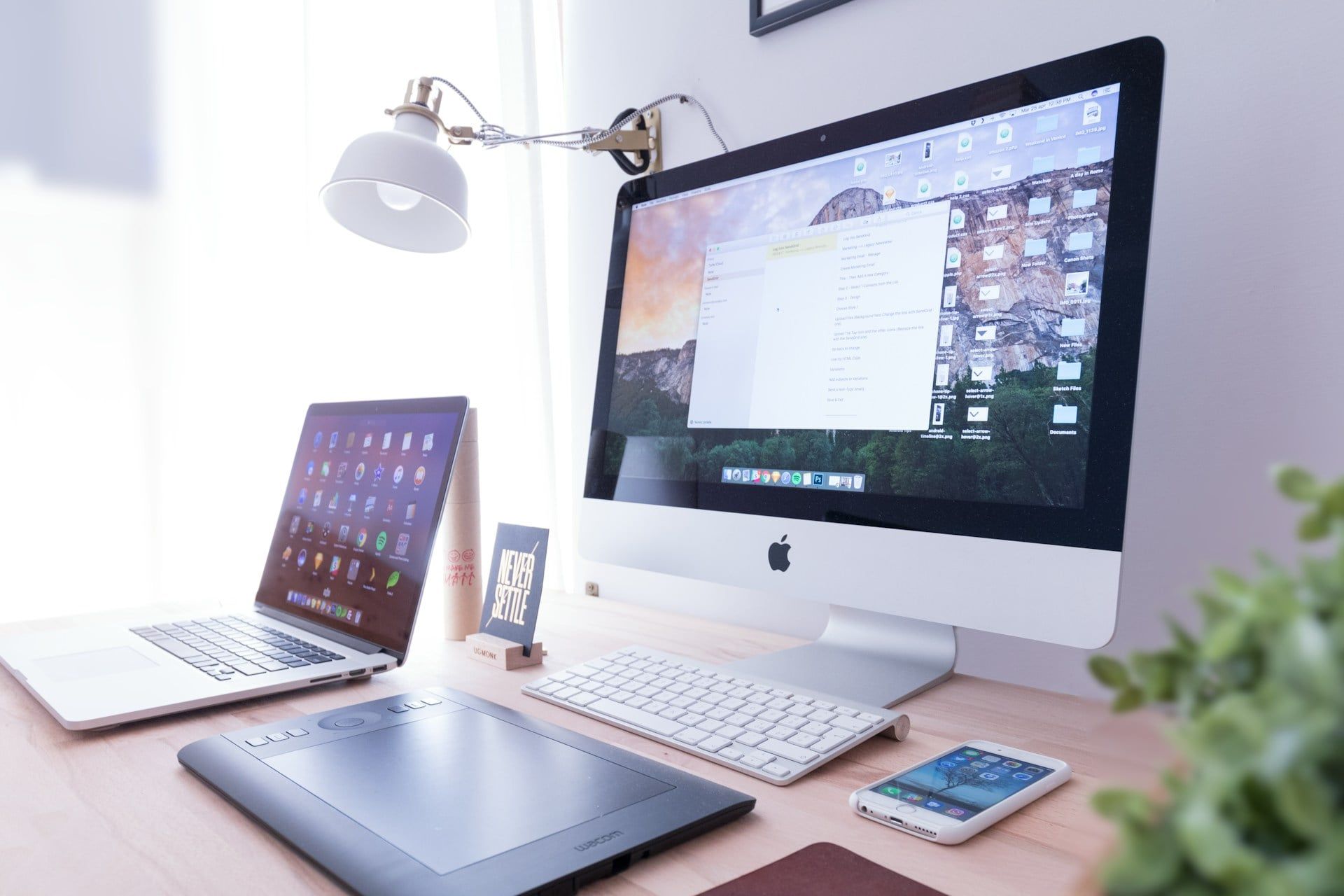 A bright aesthetic desktop computer setup with notes and gear for building high quality websites