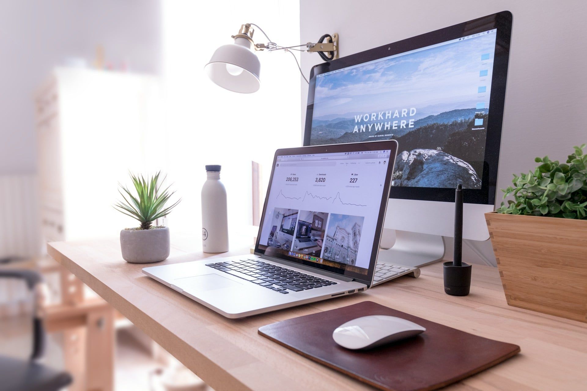 A desktop setup with a website and a laptop showing website statistics and analytics