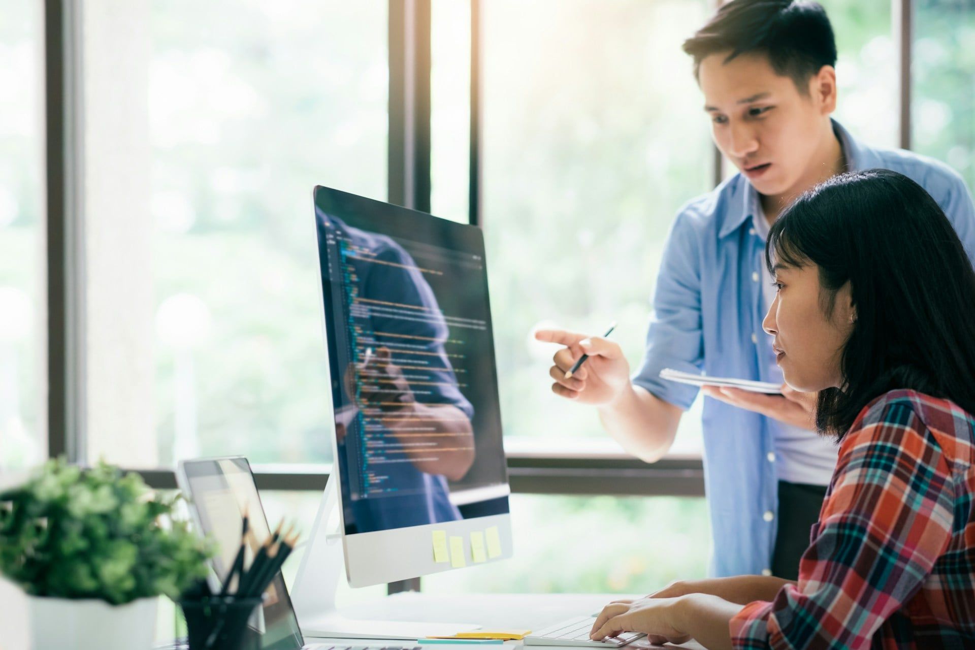 Two people in a web design team working on coding a website