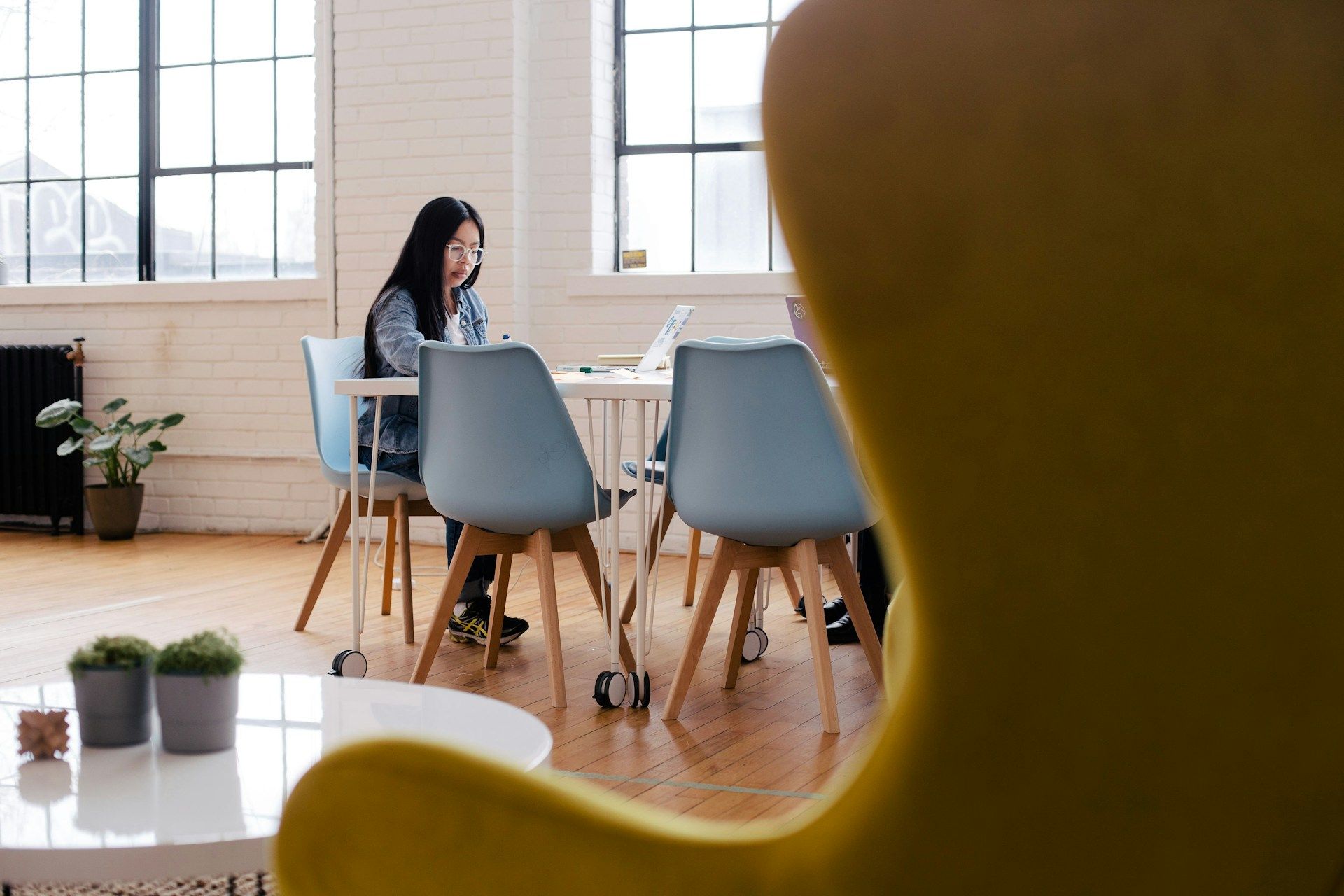  woman working on her business at her laptop in an empty coworking space