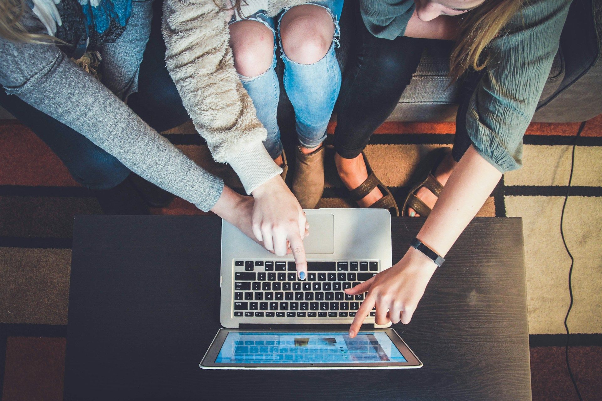 Three people reviewing the website, pointing at a laptop screen