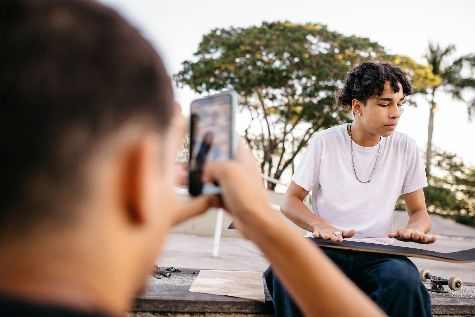 Some young skateboarders creating content on their smartphones