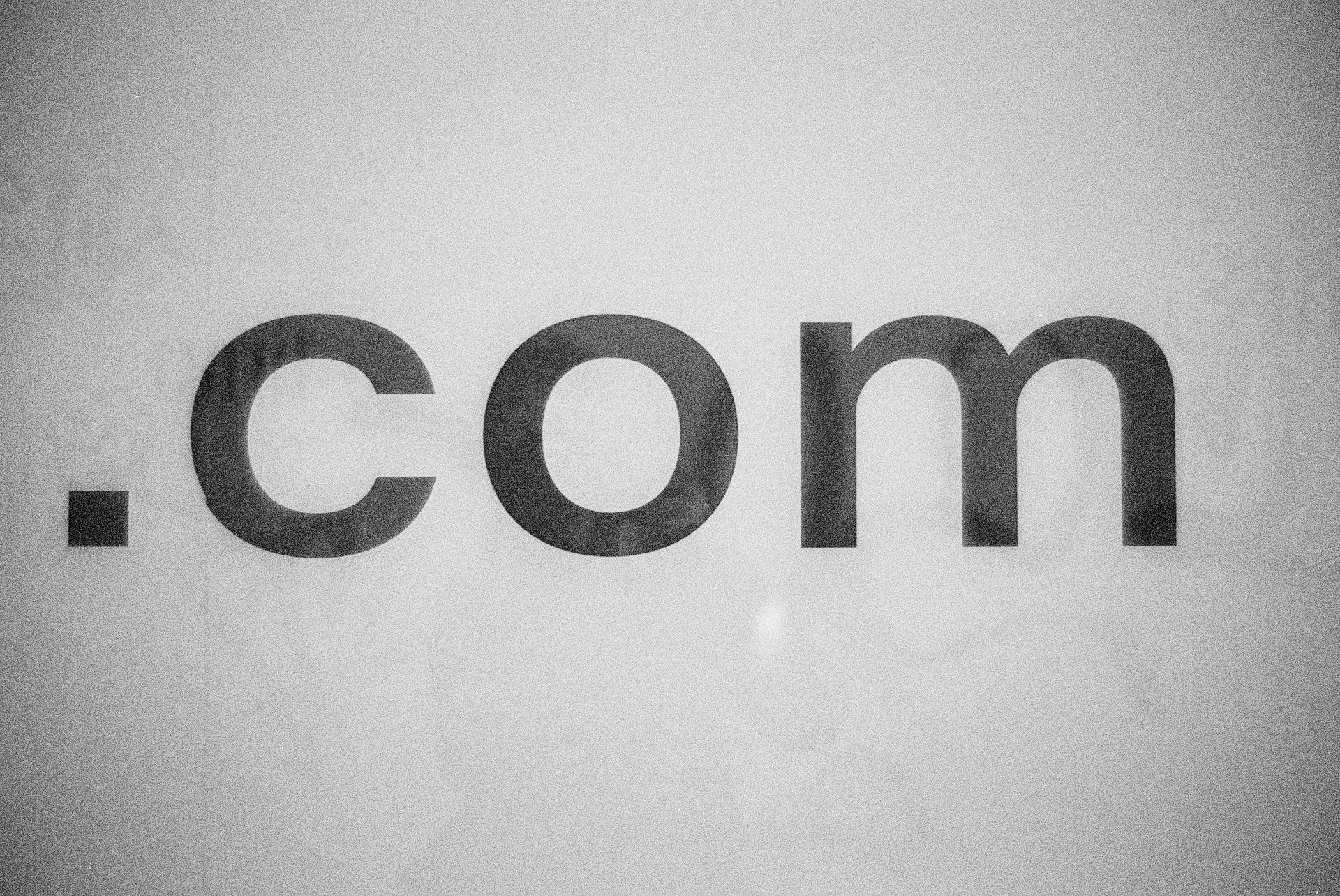  Large letters that say “.com” on a wall in black and white. 